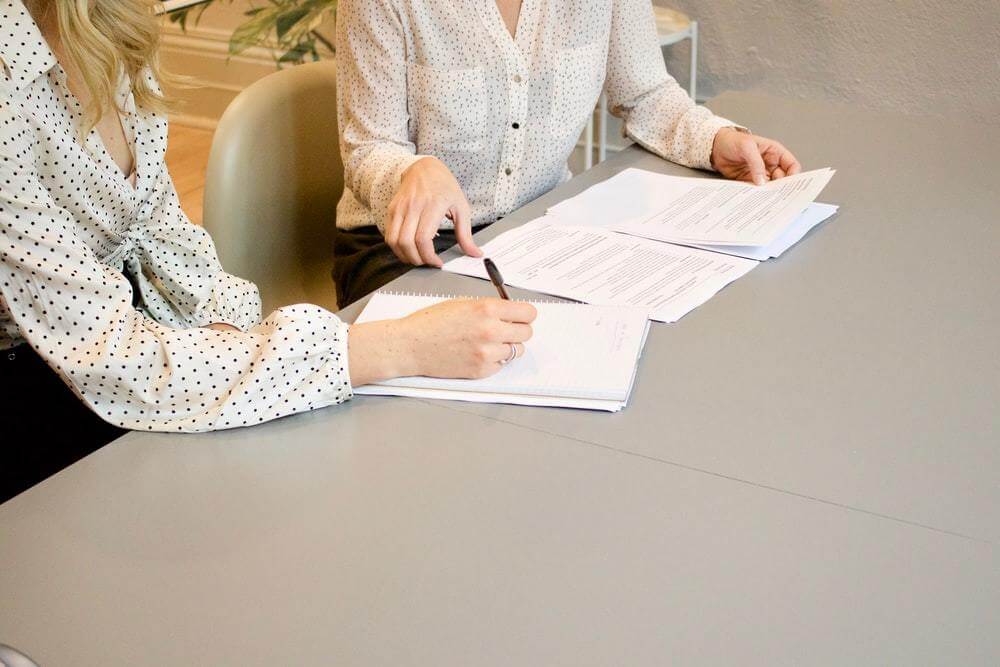 Mulheres analisando documentos da empresa.