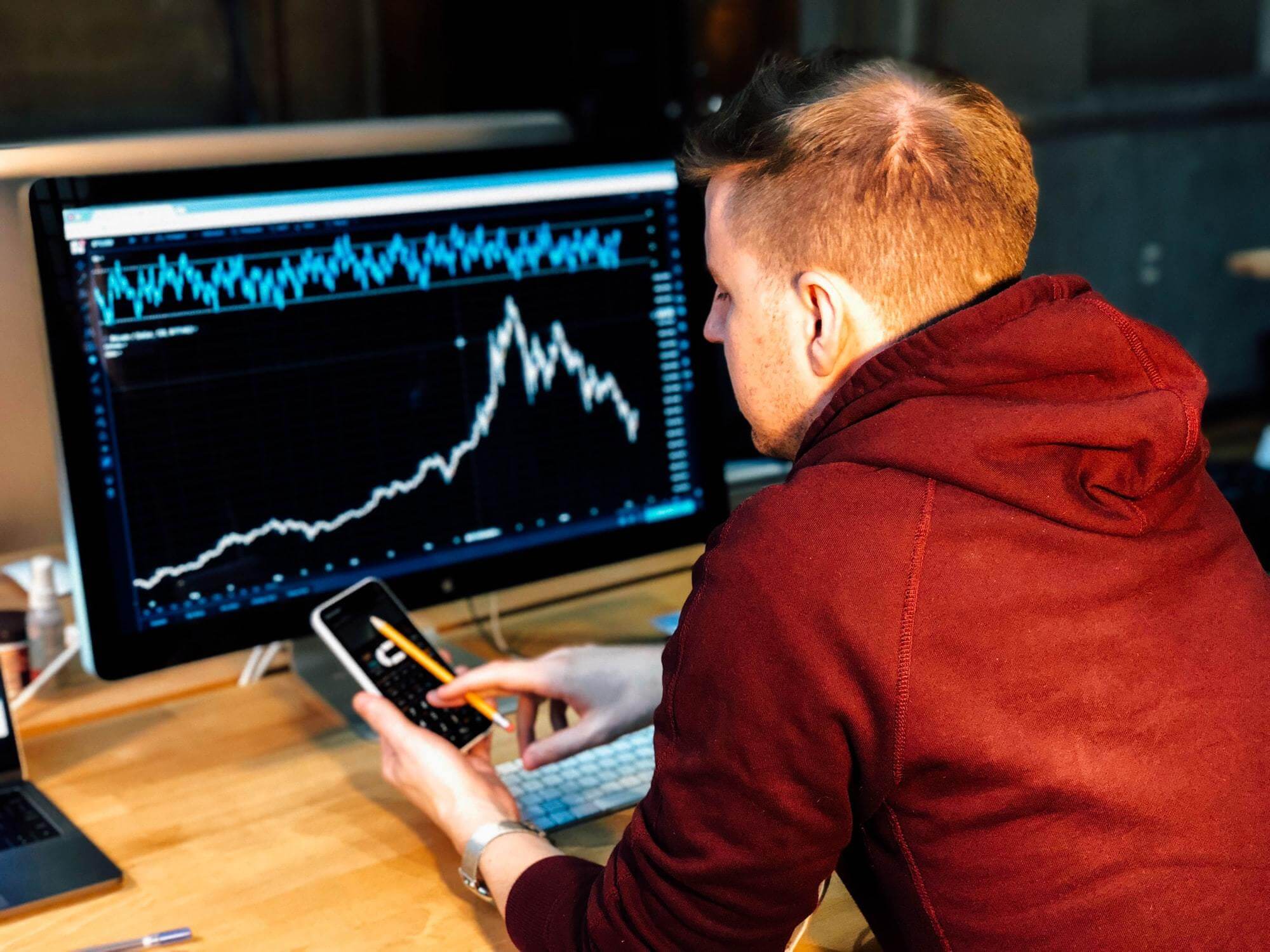 Homem analisando dados do e-commerce e fazendo contas.