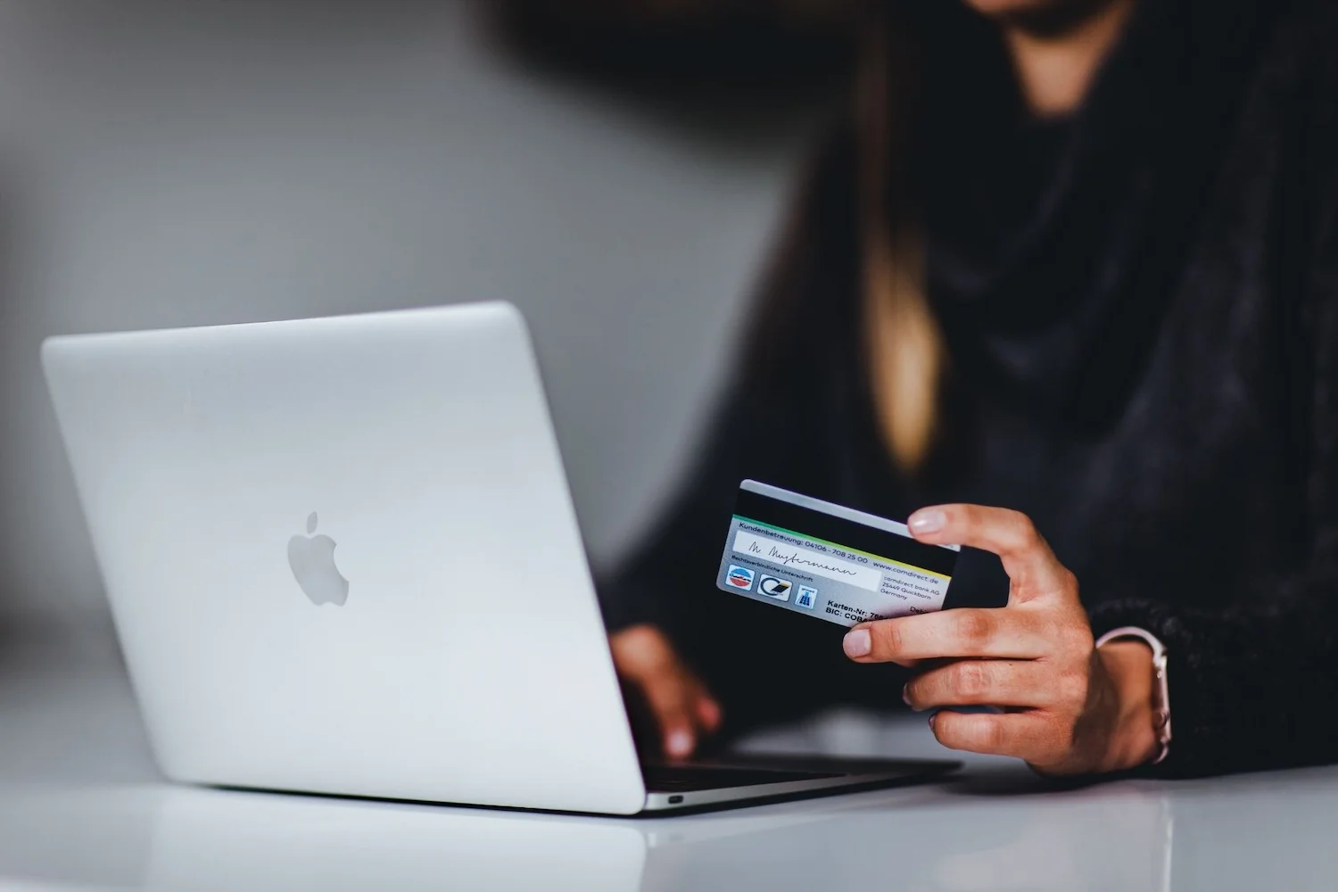 Mulher realizando compra na internet com cartão de crédito.