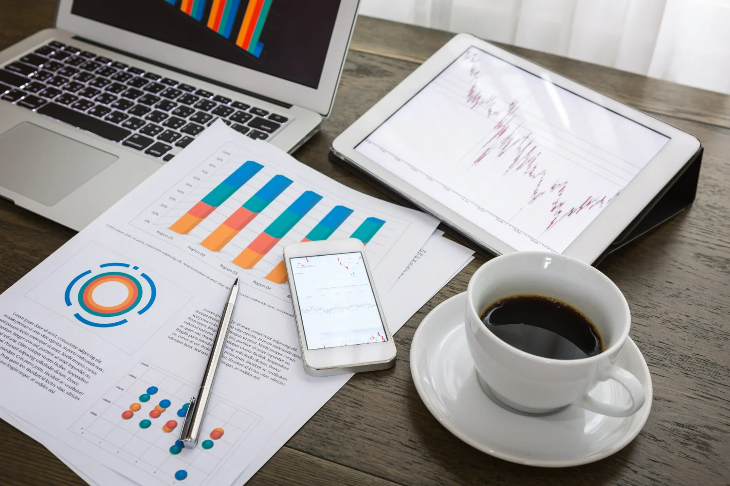 Mesa com café e gráficos com indicações financeiras representando o CFO financeiro