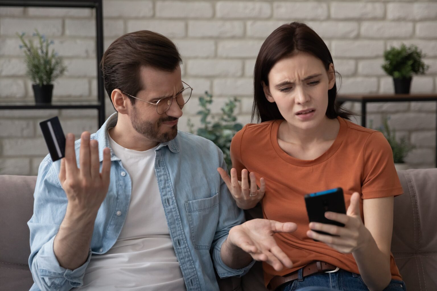Homem e mulher olhando para o celular com expressão de indignação após chargeback nos marketplaces