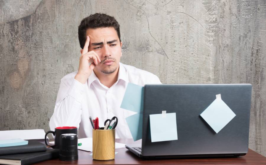 Homem olhando com expressão de dúvida para o computador após um chargeback