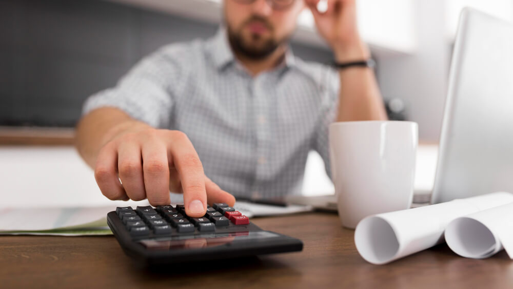 Empresário calculando custos e lucros para melhorar o desempenho das vendas de final de ano.