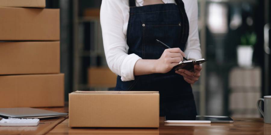 Profissional organizando pedidos e processos da logística da Amazon em operação de e-commerce.