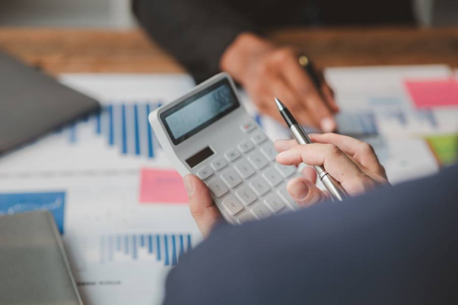 Equipe realizando cálculos e conferência de pagamentos relacionados a quando o Mercado Livre paga pelas vendas.