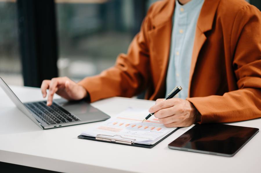 Pessoa analisando relatório de repasse de marketplace em busca de taxas de subadquirente